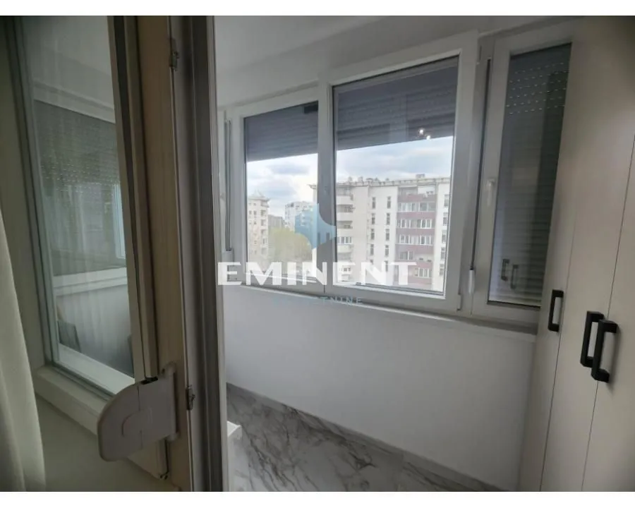 Enclosed balcony with city view.