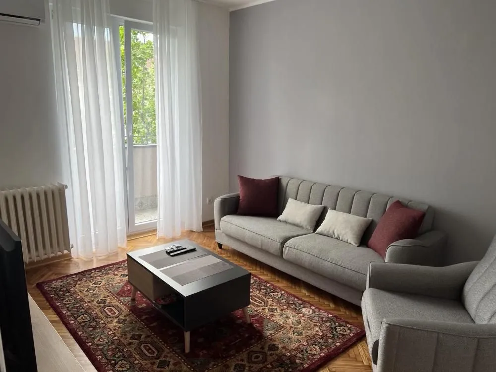 Living room with a gray sofa, coffee table, and access to the terrace.