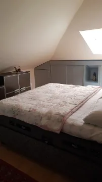 Svijetla spavaća soba u potkrovlju sa velikim krevetom i praktičnim plakarima. - image 8