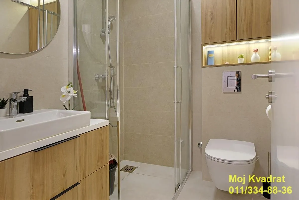 Modernly equipped bathroom with a walk-in shower, washbasin, and toilet.