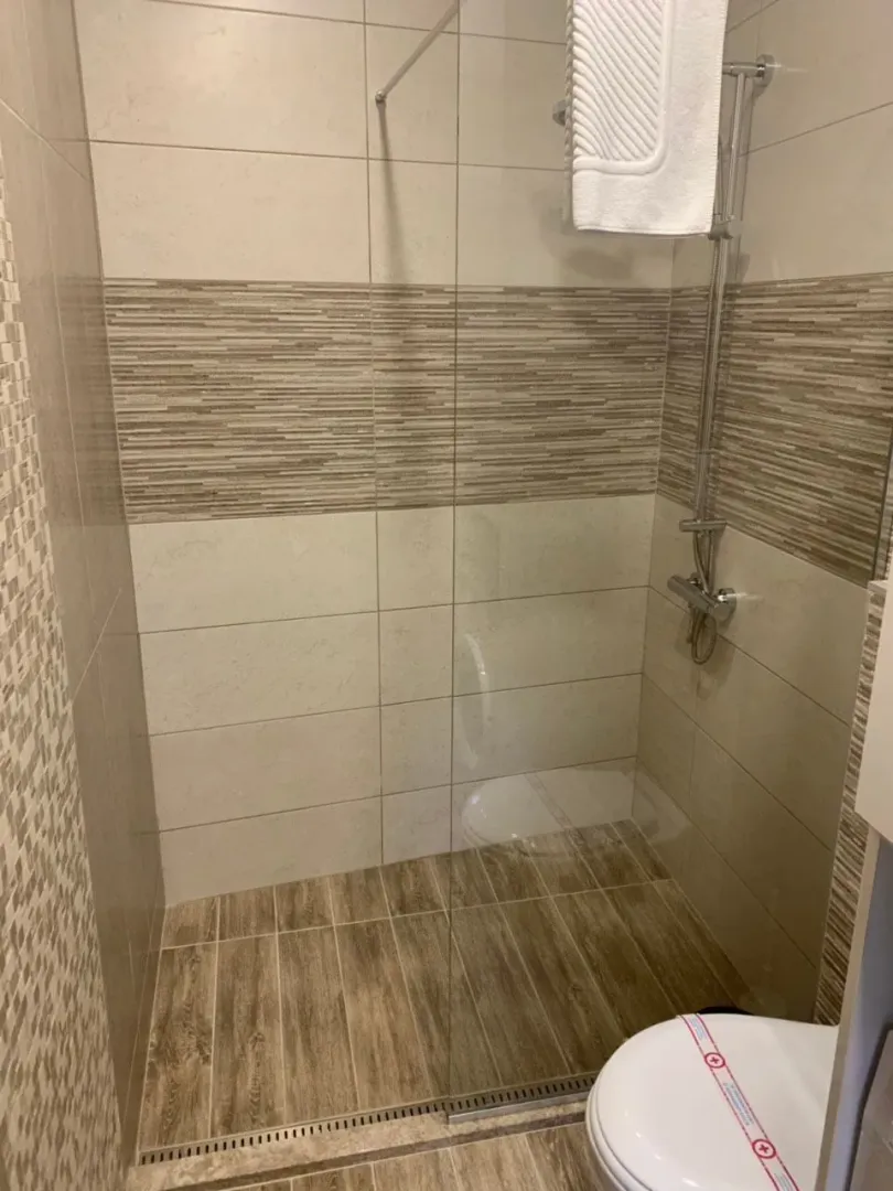 Modern bathroom with a walk-in shower and ceramic tiles.