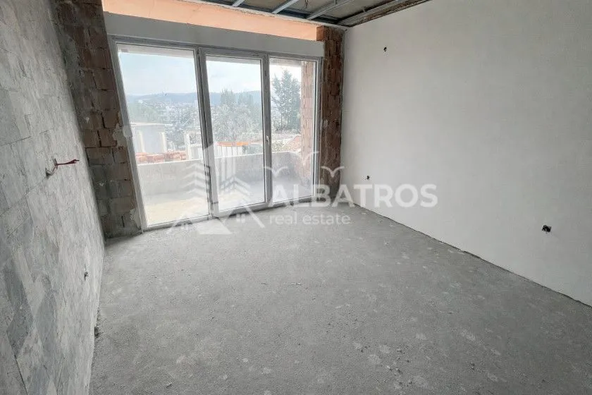 Prazna prostorija u izgradnji sa balkonskim vratima i pogledom.
