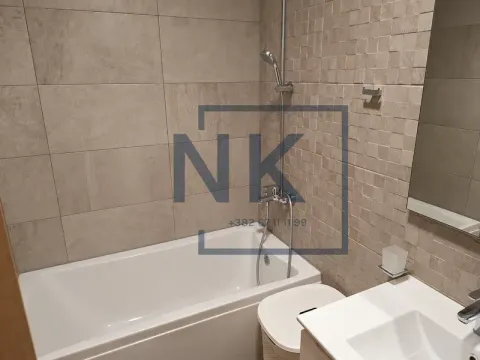 Bathroom equipped with a bathtub, washbasin, and neutral-toned tiles. - image 9