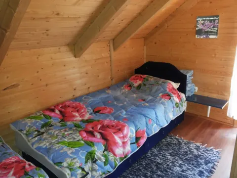 Jednostavna spavaća soba u drvenom potkrovlju sa jednim krevetom. - image 13