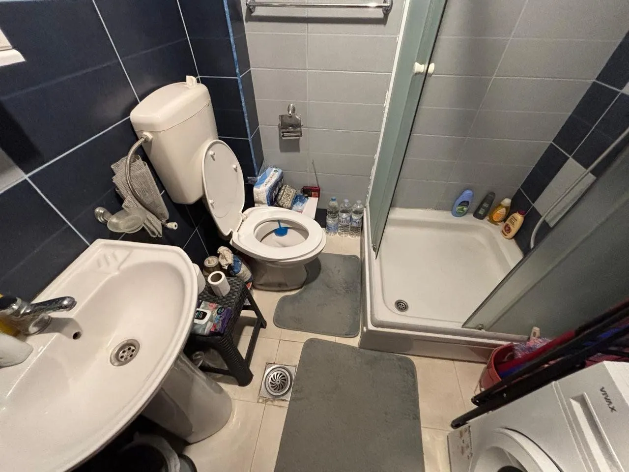 Manje kupatilo sa tuš kabinom, umivaonikom i toaletom.