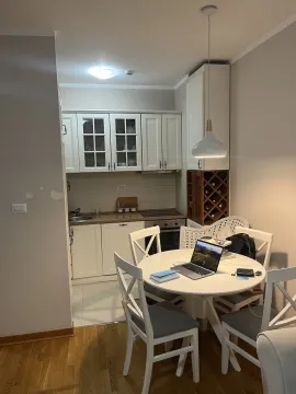 A bright kitchen area with a dining table and chairs. - image 2