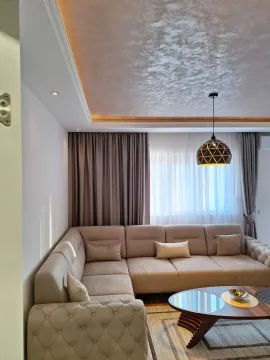 Svijetla dnevna soba sa velikom ugaonom garniturom i modernim lusterom. - image 8