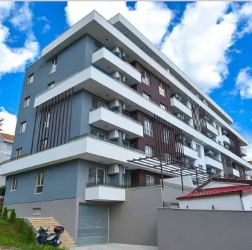 Exterior of a modern apartment building with balconies and a garage. - image 9