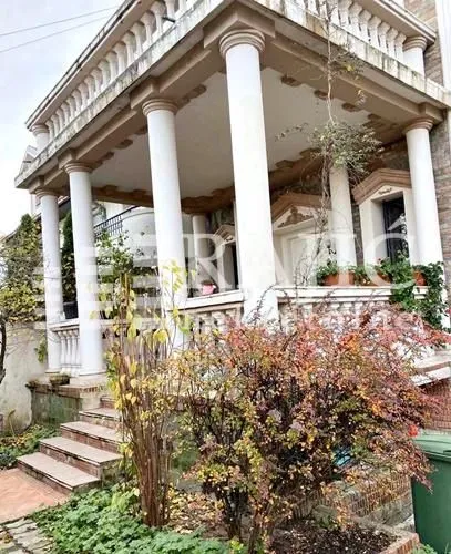 Exterior of a house with a porch, columns, and a landscaped yard.