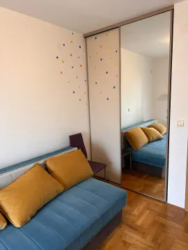 Children's bedroom with a bed, mirrored wardrobe, and wall decorations. - image 4