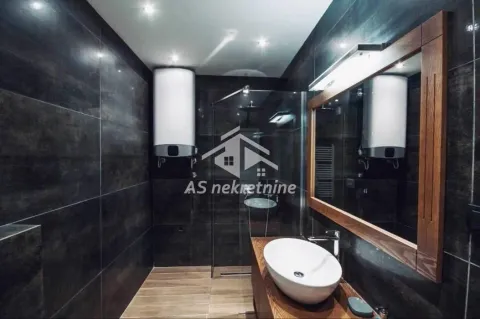 Modern bathroom with a walk-in shower and dark tiles. - image 11