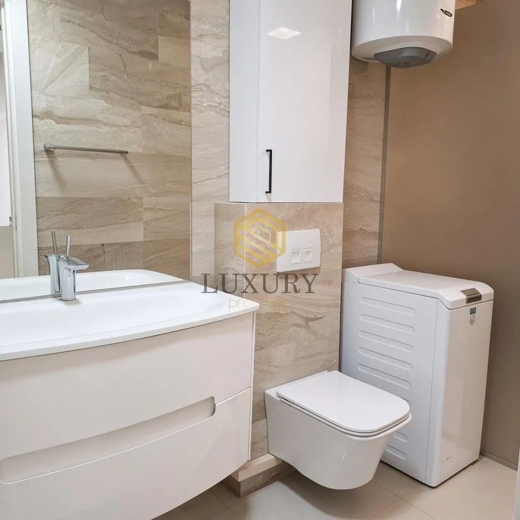 Modern bathroom equipped with a washbasin, toilet, and washing machine.
