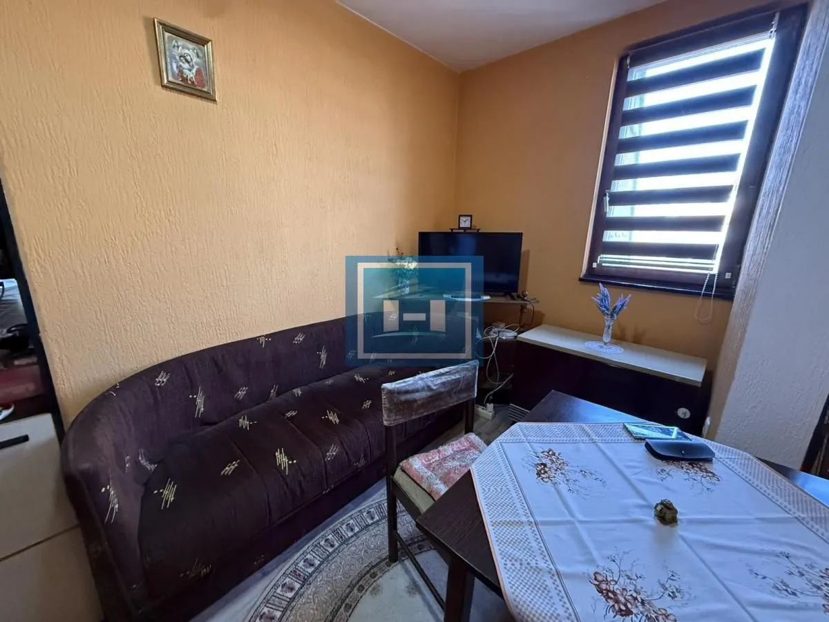 Smaller living room with a sofa, dining table, and television.