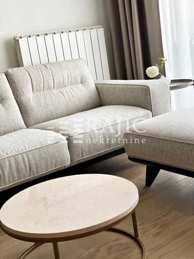 Bright living room with a beige sofa and a round coffee table.