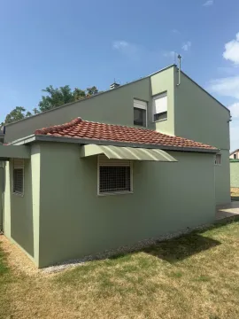 Pogled na spoljašnjost kuće sa zelenom fasadom i krovom od crijepa. - image 12
