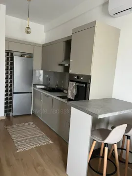 Modern kitchen with built-in appliances and a breakfast bar. - image 6