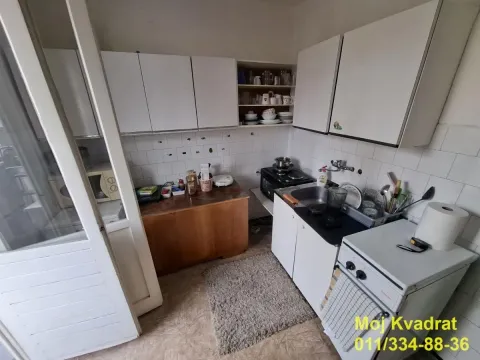 Small kitchen with white cabinets, stove, and sink. - image 4