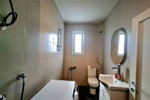 Bathroom equipped with a shower cabin, sink, toilet, and washing machine. - image 6