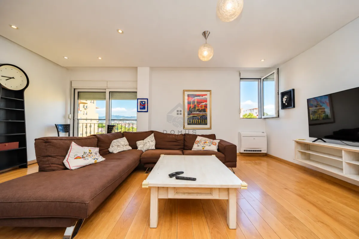 Living room with a large brown sectional sofa, coffee table, and television.
