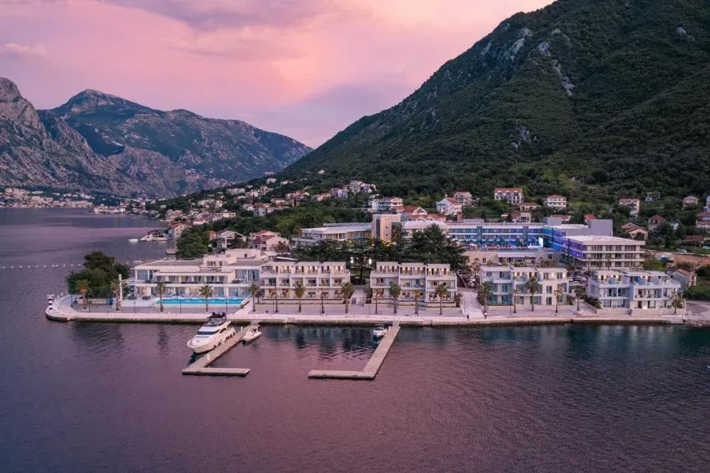 Pogled iz vazduha na hotelski kompleks i obalu sa jahtama.