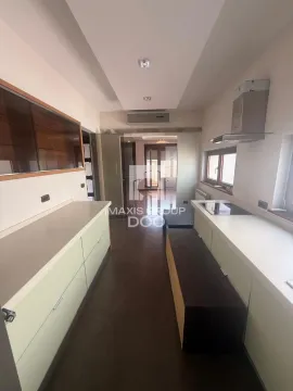 Narrow kitchen with white cabinetry and built-in appliances. - image 11