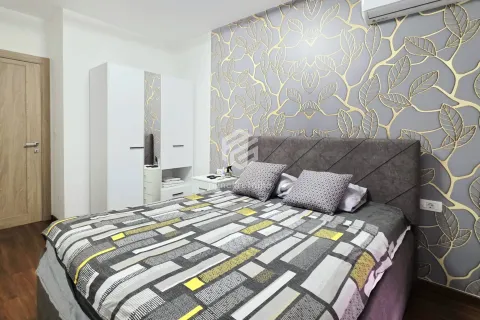 Furnished bedroom with a double bed, white wardrobe, and patterned wallpaper. - image 10