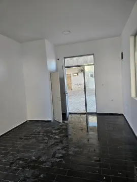 Empty room with dark tiles and an exit to the yard. - image 5