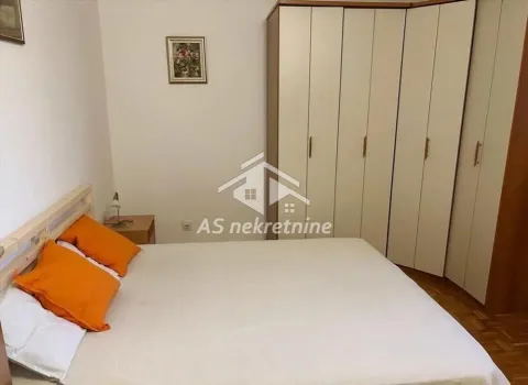 Furnished bedroom with a double bed and a wardrobe. - image 7