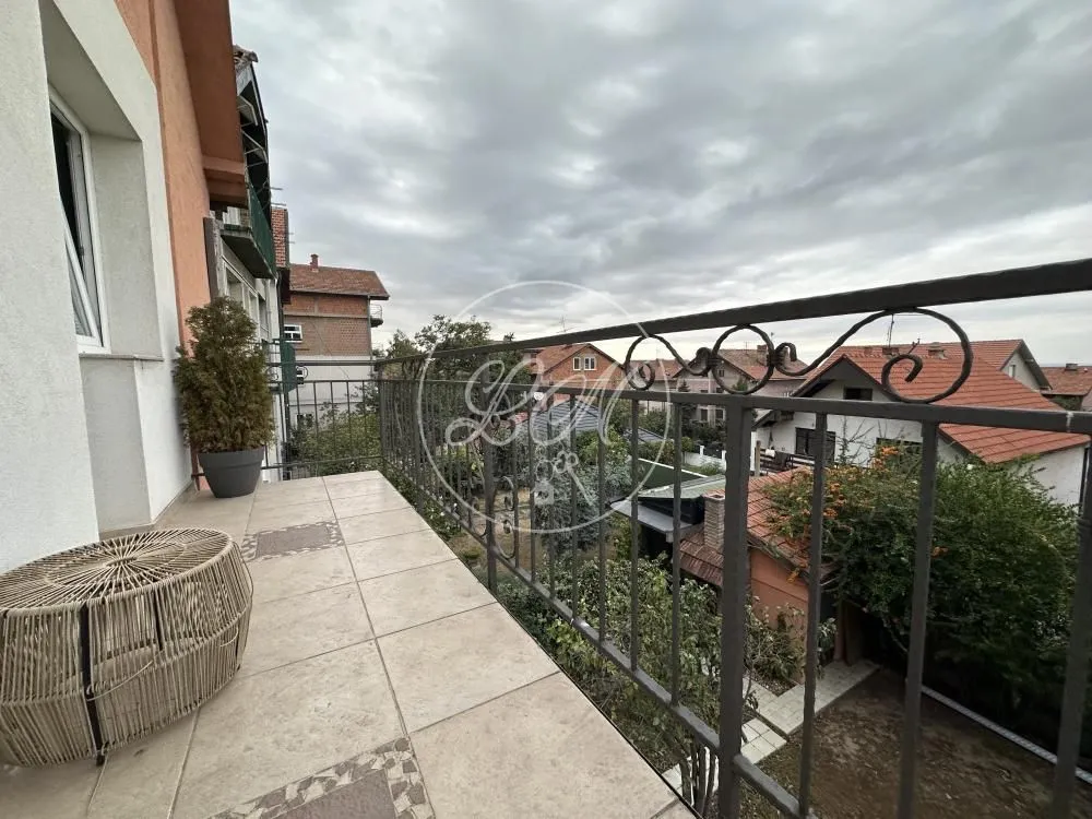 Balcony with tiled flooring and wrought iron railing overlooking the yard and neighborhood.