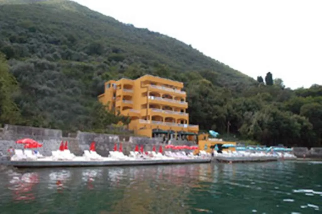 Žuta višespratna zgrada na samoj obali sa uređenom plažom.