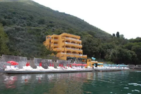 Žuta višespratna zgrada na samoj obali sa uređenom plažom. - image 9