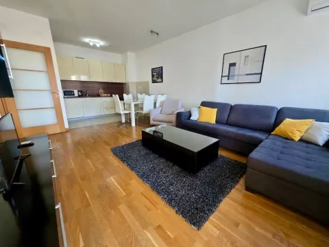 Dnevna soba sa garniturom, trpezarijom i ugrađenom kuhinjom u pozadini. - image 3