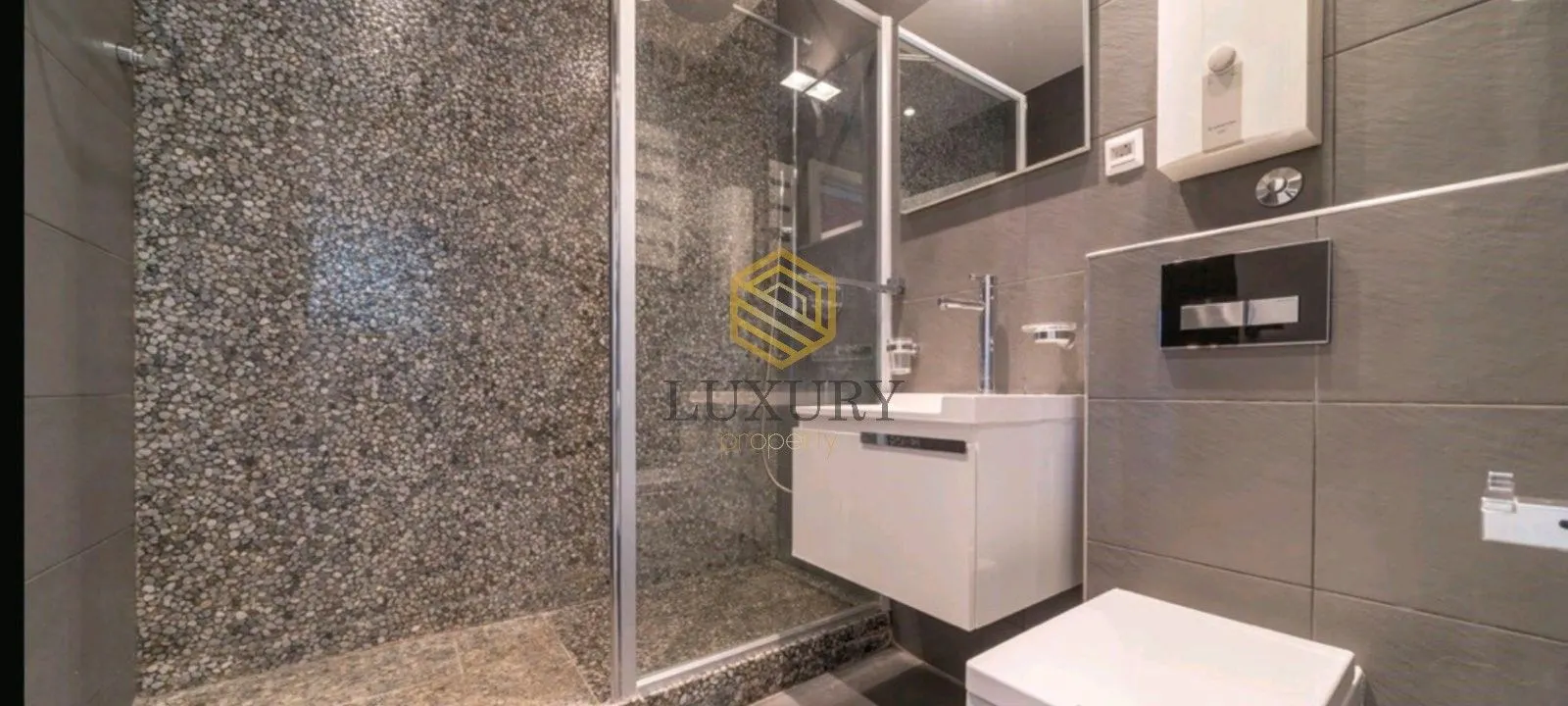 Moderne kupatilo sa tuš kabinom, umivaonikom i wc šoljom.