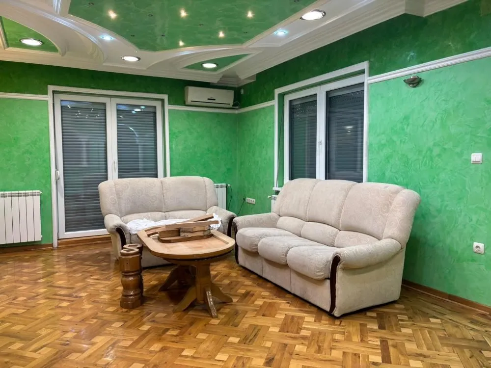 Living room with seating furniture and wooden flooring.