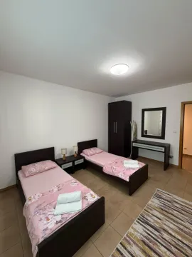 Namještena spavaća soba sa dva singl kreveta i ormarom. - image 8