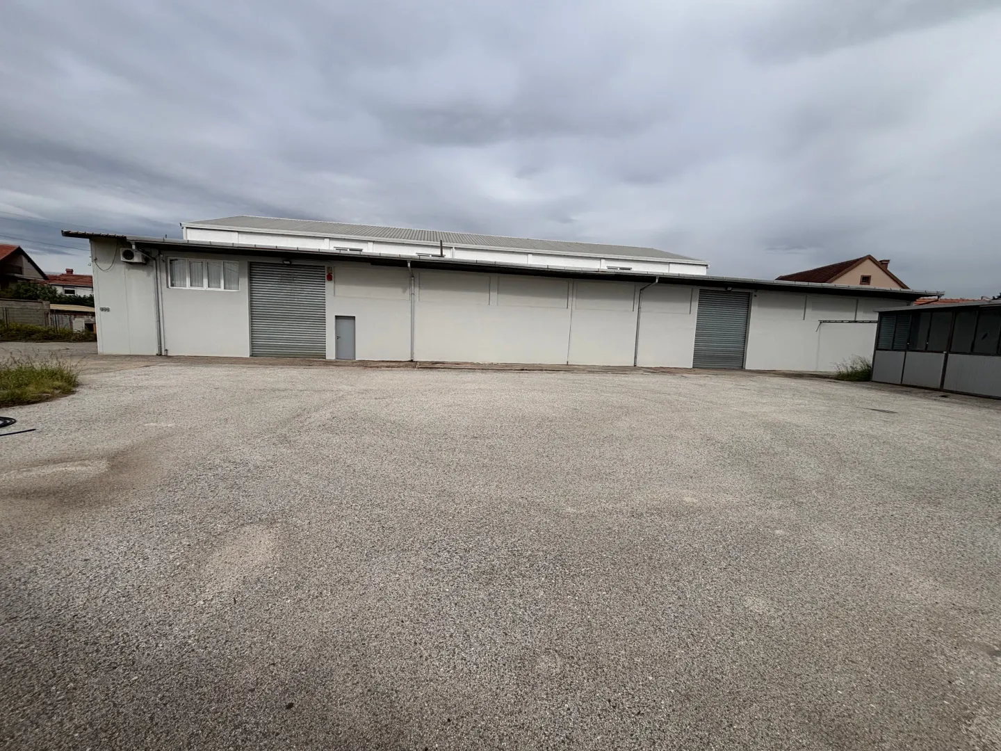 Exterior view of an industrial building with a large paved courtyard.