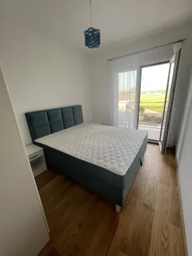 Bright bedroom with a double bed and balcony access. - image 12