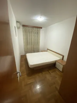 A simple bedroom featuring a double bed and parquet flooring. - image 9