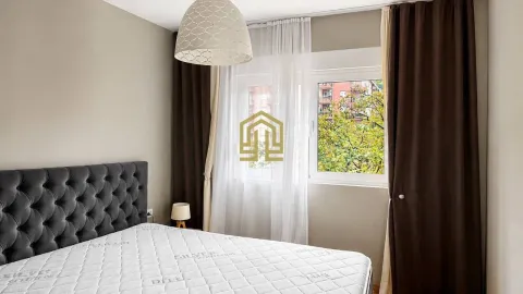 Bright bedroom featuring a grey tufted headboard and a large window. - image 7