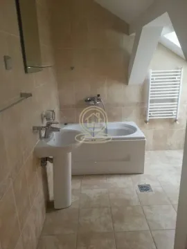 Tiled bathroom with a bathtub, washbasin, and radiator. - image 13