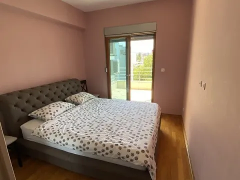 Bright bedroom with a double bed and access to a balcony. - image 5