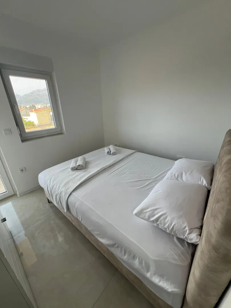 Bright bedroom with a double bed and a window.