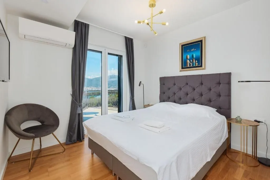 Bright bedroom with a double bed, air conditioning, and access to the terrace.