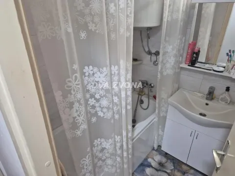 Manje kupatilo sa kadom, zavesom za tuširanje i umivaonikom. - image 8