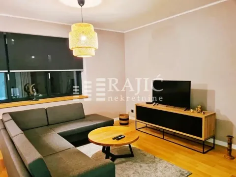 Living room with a sectional sofa, TV, and coffee table. - image 3