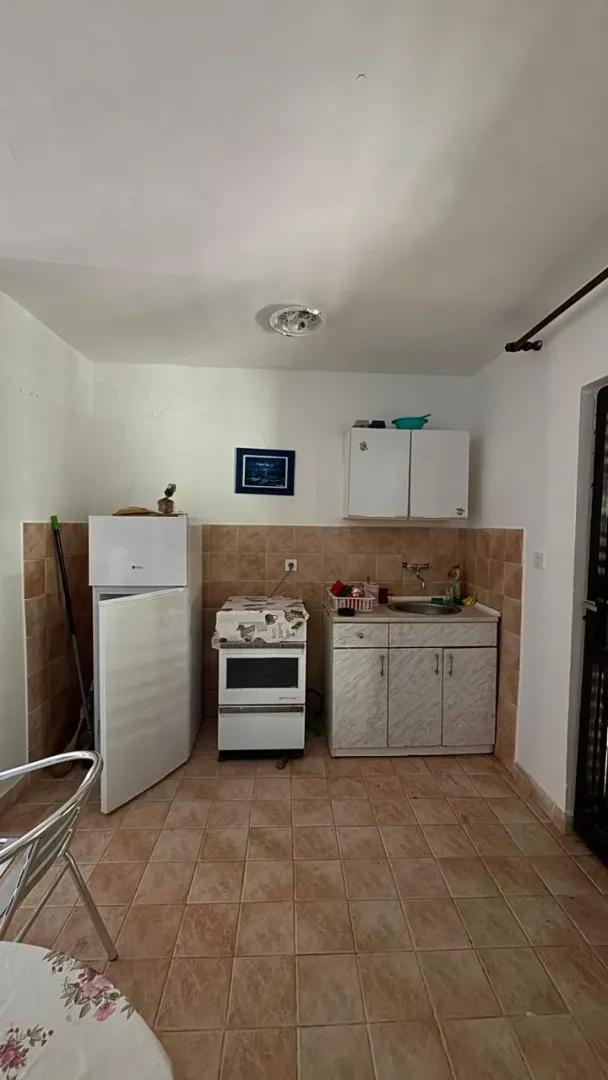 Manja kuhinja sa osnovnim elementima i frižiderom.