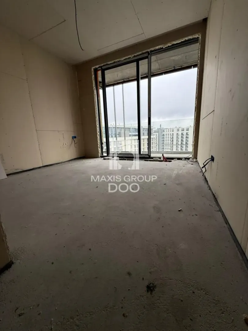 A view of an unfurnished room under construction with balcony doors.