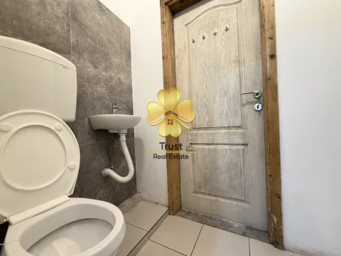 Small bathroom with a toilet, washbasin, and wooden door. - image 6