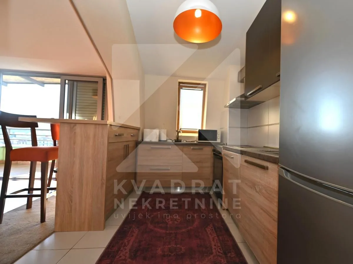 Smaller kitchen with wooden elements and a bar counter.