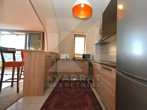 Smaller kitchen with wooden elements and a bar counter. - image 4